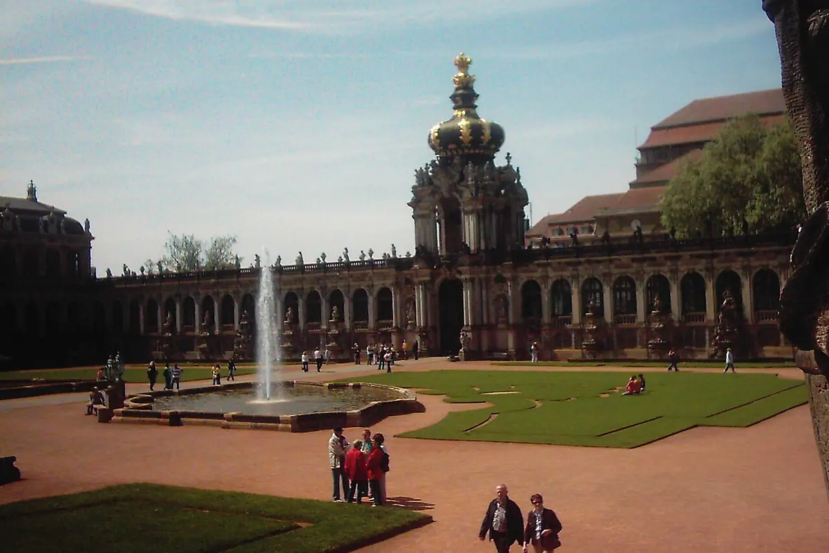 The Crown Gate across the Zwinger courtyard, with a fountain and a lawn in front and the long gallery beside it.